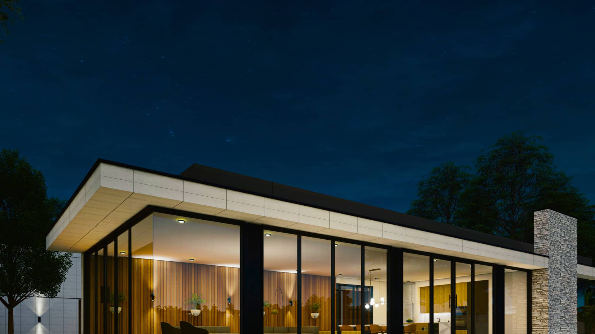 Modern luxury home exterior at night with large glass windows and warm interior lighting
