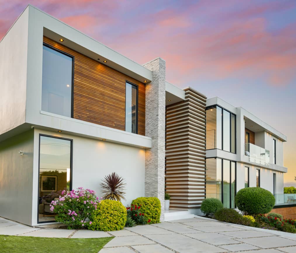 Contemporary house with sleek architectural design, surrounded by lush landscaping