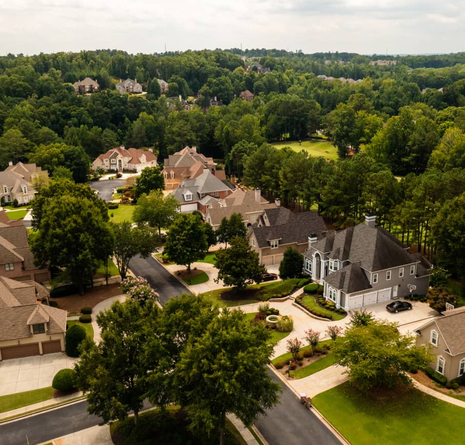 Aerial view of a tranquil residential community with well-manicured homes and greenery